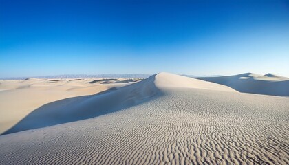 a serene expanse of pristine white sand dunes under a clear blue sky showcasing the natural beauty and tranquility of a desert landscape