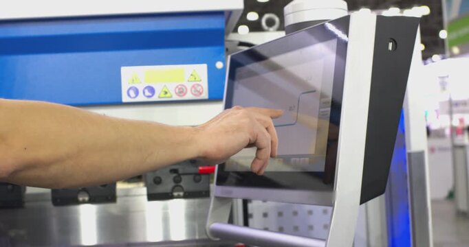 Factory operator using touchscreen industrial machine interface
