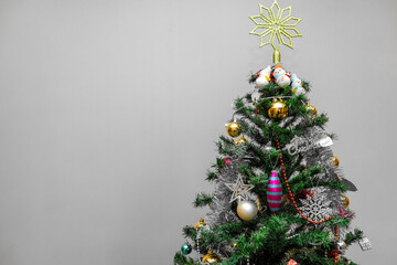 Christmas composition, baubles, bows, animals, bells, lit garlands on a festive xmas fir tree against the decorative background. Decorations ornaments, ribbons,  glowing lights warm holiday new year