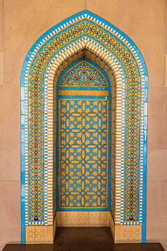 View of a vibrant archway adorned with intricate turquoise and gold geometric patterns creates a stunning focal point, Muscat, Muscat Governorate, Oman.