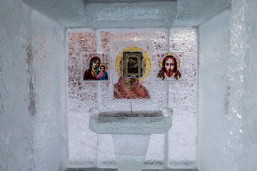 View of a small ice chapel with religious icons in Irkutsk, the icy walls reflecting the dim light, a serene and ethereal scene, Irkutsk, Irkutsk Oblast, Russia.
