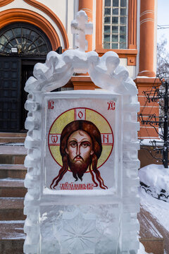 View of a frozen icon sculpture gleams with an ethereal glow, contrasting against the backdrop of a traditional building in Irkutsk, Irkutsk Oblast, Russia.