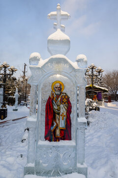 View of an ice sculpture of a saint in a snow-covered landscape, a testament to winter artistry and faith, Irkutsk, Irkutsk Oblast, Russia.
