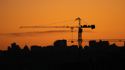Silhouette of a tower crane above a city