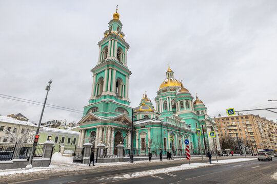 View of the vibrant green and gold topped Cathedral of the Immaculate Conception standing tall amidst a snow-dusted cityscape, Moskva, Moskva, Russia.