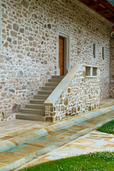 Obraz premium Stone stairs to porch with wooden door, stone building facade, beautiful architectural details