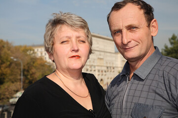 Obraz premium A man and woman are standing next to each other. The woman is wearing a black shirt and necklace