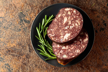 Blood sausage with meat offal accompanied by rosemary.
