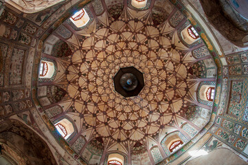 View of an ornate domed ceiling with intricate geometric patterns and colorful floral designs, a testament to architectural artistry, Lahore, Punjab, Pakistan.