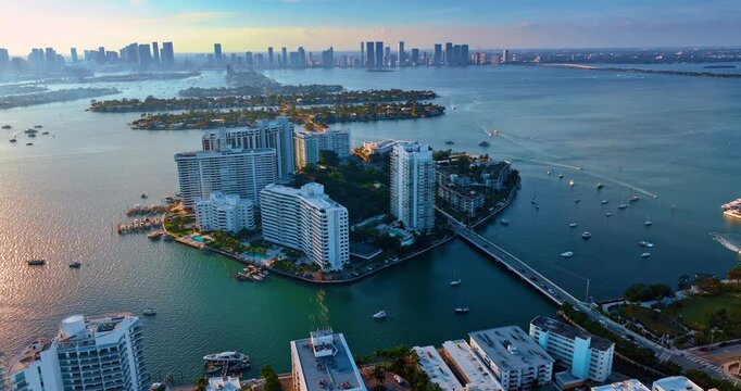 Flying closer to man-made islands in Brickel Key, Miami, Florida. Spectacular cityscape in Biscayne Bay at sunset time.