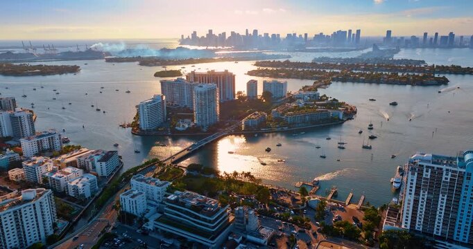 Smoke spreads over fantastic islands in Brickel Key, Miami, Florida. View on the numerous boats on the waterscape of Biscayne Bay at sunset. Aerial perspective.