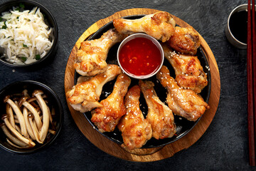 Baked chicken wings in asian style with sauces.