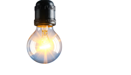 A glowing lightbulb hangs against a black backdrop, emitting a bright, warm light