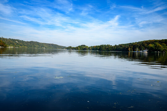 Extreme Low Angle View of Calm Blue Water Reflecting the Sky and Forest-Covered Hills on the Horizon, Summer Nature Landscape Panorama