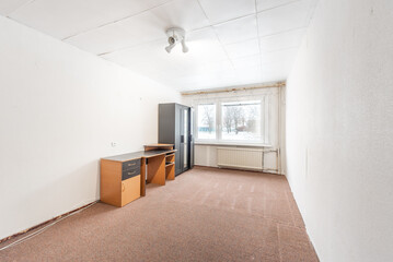 Old Abandoned Spacious Bright Office Room With Minimal Furniture and Large Window. Home Interior. 