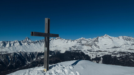 woodden cross on folluhorn summit during winter , switzerland