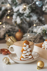 Cup of Hot Coffee with Christmas Gingerbread tree-shaped Cookies and Ornaments in Festive Setting
