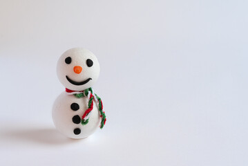 little smiling handmade snowman with scarf on white background with copy space