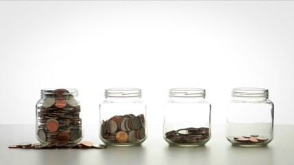 Four jars showing gradual coin accumulation and savings growth