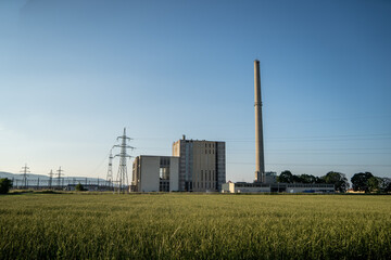 Industrial power plant with smokestack in rural landscape