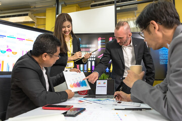 Male and female businesspeople team working together in business meeting with company statistic chart on screen background