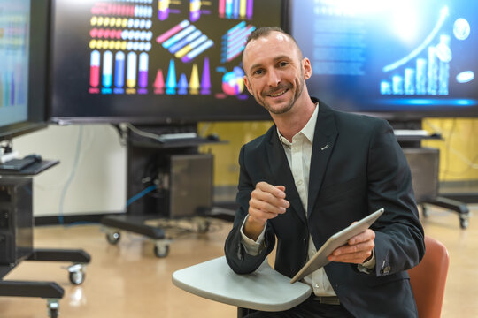 Caucasian businessman with digital tablet working in business meeting room - Powered by Adobe