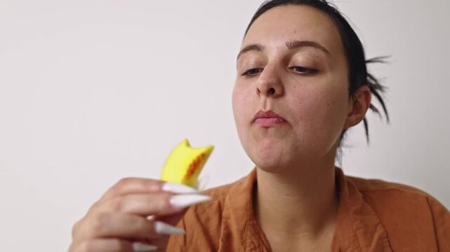 A young woman savoring a fresh and juicy mango slice as a healthy snack. She enjoys the natural sweetness, highlighting healthy eating and a simple, refreshing lifestyle.