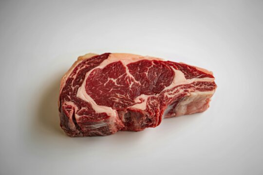 A high-quality food photography shot of a thick, marbled ribeye steak