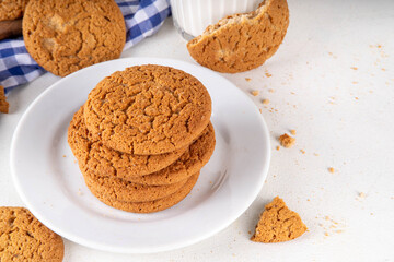 Homemade golden-brown Gingersnap Cookies stack on kitchen table. Traditional american ginger snap cracked biscuit cookies, with milk glass, copy space