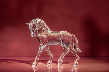 Crystal horse on red background.