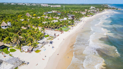 Tulum Beach, Quintana Roo, Mexico, Beach with palm trees and houses in the background. The beach is crowded with people enjoying the day