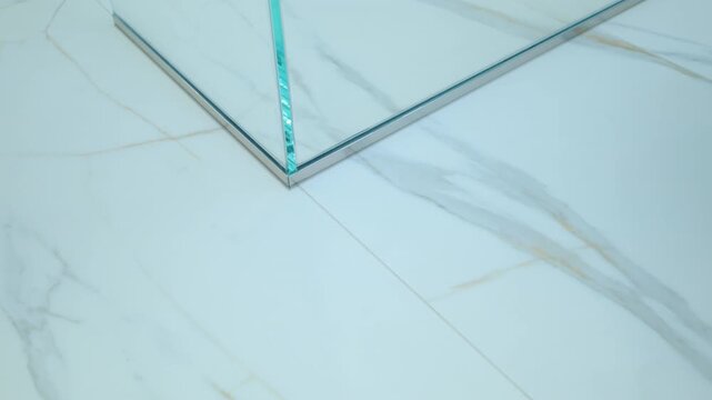 The elements of the Modern Bathroom. Glass shower walls with corner on the floor in the modern bathroom. Close up move view