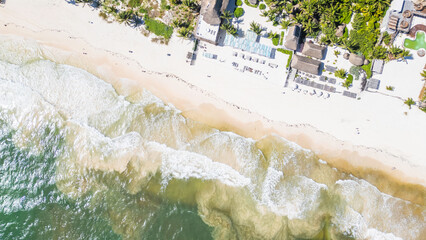 Tulum Beach, Quintana Roo, Mexico, Beach with a lot of people and a hotel in the background. The water is a light blue color