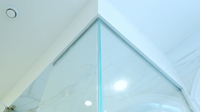 The elements of the Modern Bathroom. Glass shower walls with corner on the ceiling in the modern bathroom. Close up move view