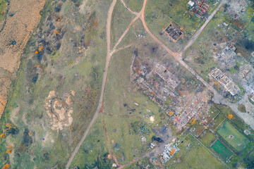 Ruins of residential buildings in a war zone: aerial view of a village destroyed by artillery fire. Concept of humanitarian crisis and aggression