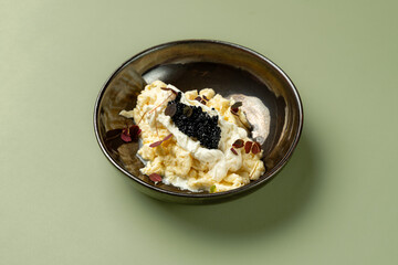 Creamy texture meets the rich flavor of caviar, beautifully arranged in a stylish bowl. The dish is garnished with microgreens, creating a visual feast