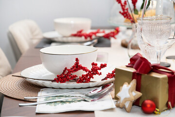 Festive Christmas table setting with decor and gift for Christmas eve. Cozy atmosphere,.