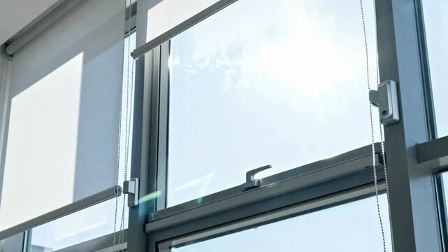 Dynamic sensordriven sun shading system extending over a glass window to reduce glare and heat indoors.