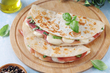 Traditional Italian dish Piadina romagnola - flat bread with mozarella and proscuitto