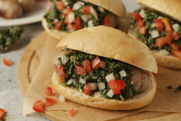 Choripan - bread with grilled sausages with chimichurri sauce, traditional Argentinian fast food dish	