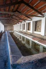 Obraz premium Covered Historic Stone Wash Basin with Roof