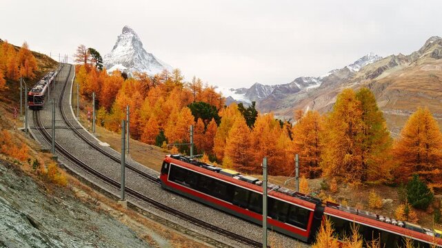Two Trains on Gornergrat Railway Going Towards Each Other, Matterhorn Mountain and Yellow Larches in Autumn. Fall Colors. Swiss Alps. Zermatt, Valais, Switzerland