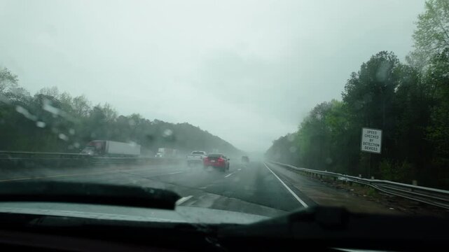 Driving car on the interstate highway road on heavy rainy weather. POV view from the front passenger seat