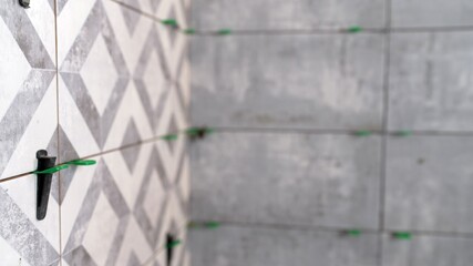 Tiling bathroom wall with patterned and plain ceramic tiles