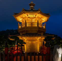 Diamond Hill, Kowloon, Hong Kong : perfectly symmetrical view of golden pavilion and red bridges in Nan Lian Garden at night. Traditional Chinese architecture