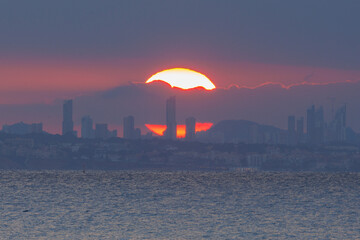 Sol de atardecer sobre rascacielos de Benidorm desde Calpe, Espa&ntilde;a