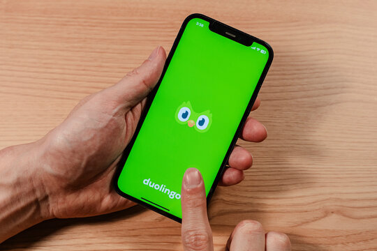 Hand holding smartphone displaying DUOLINGO mobile application loading screen - Seoul, South Korea - November 23 2025