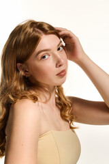 Obraz premium Natural beauty shines through in serene white studio with a lovely redhead
