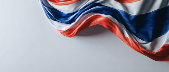 A close-up view of the draped flag of Thailand, showcasing the country's national colors in a flowing fabric texture, it represents a sense of national pride.