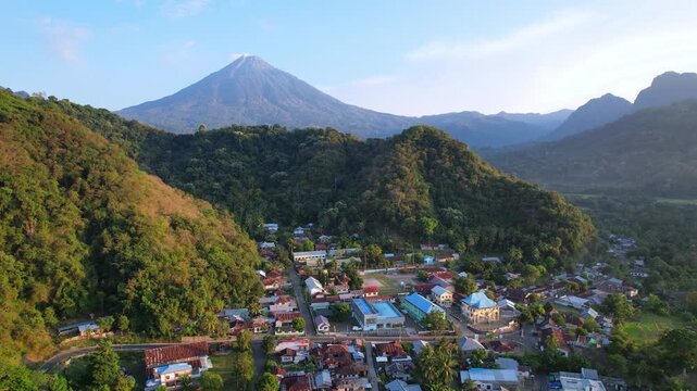 Aerial drone sunrise footage of Mauponggo village, with the majestic Ebulobo volcano in the background, in Flores island, Indonesia
